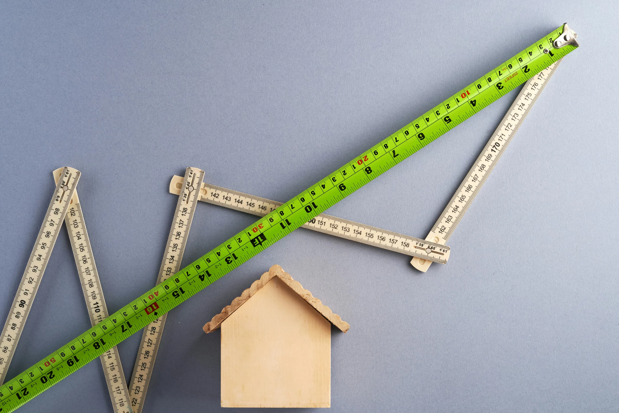 Illustration de l’encadrement des loyers à Paris avec une maison et des mètres de mesure