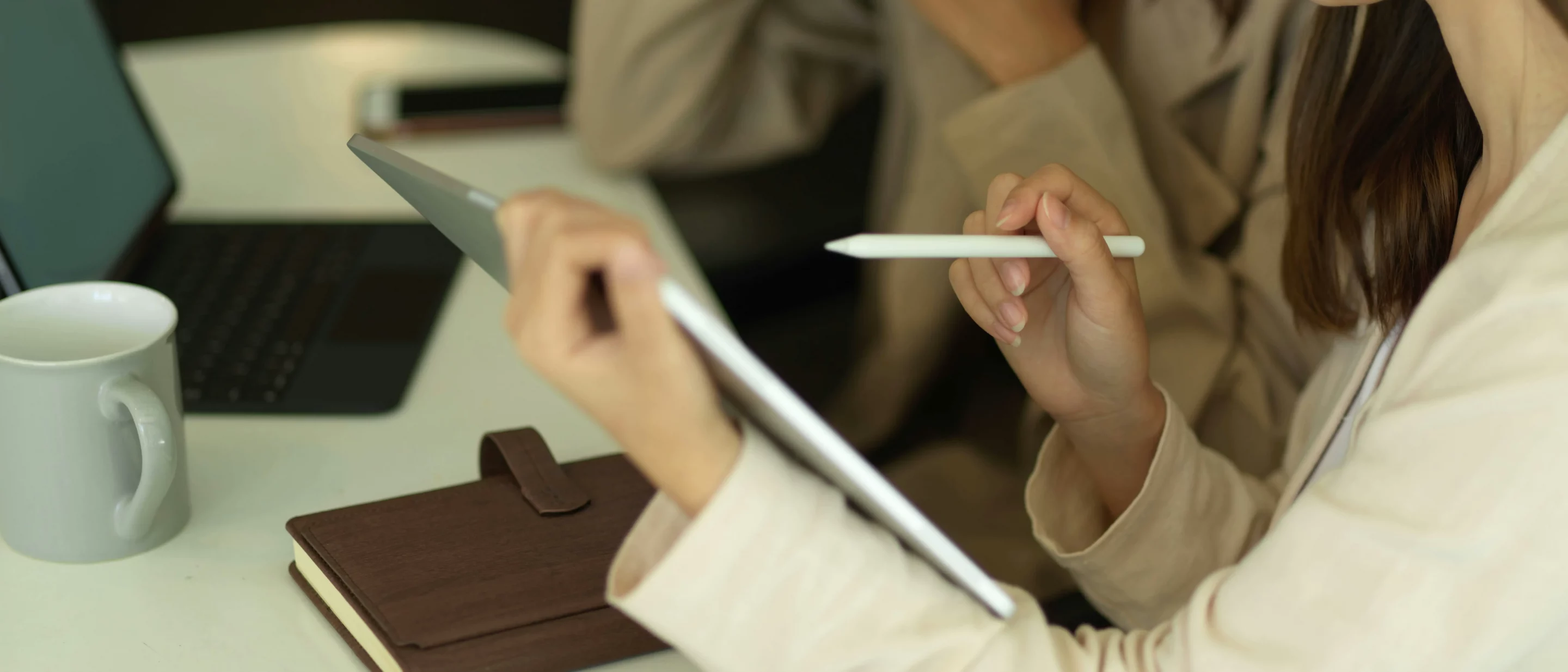 Travail d’analyse sur tablette et carnet — illustration de l’accompagnement humain et expert de Providence Immobilier face aux plateformes en ligne